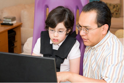 Photo of a boy and man looking at a computer screen.